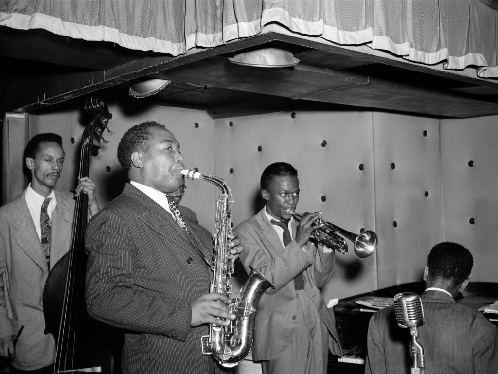 The Charlie Parker Quintet at the Three Deuces in New York City, circa 1945; left-to-right Tommy Potter (bass), Parker, Max Roach (drums, behind Parker’s left shoulder), Miles Davis (trumpet), and Duke Jordan (piano)