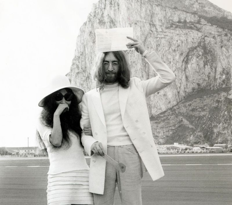 John Lennon (1940-1980) and Yoko Ono (born 1933) immediately after their wedding in Gibraltar (the famed “rock” is in the background); John is holding their marriage certificate over his head